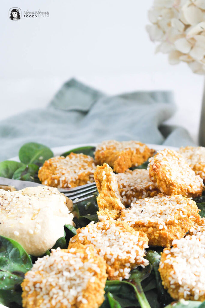 Karotten-Sesam-Bällchen mit geröstetem Karotten-Hummus auf frischem ...